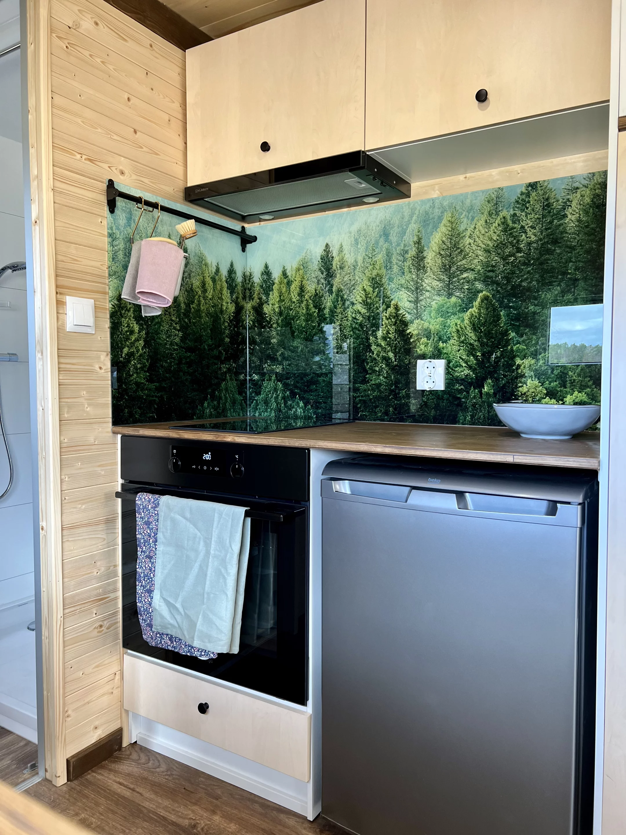 The Sunshine tiny house's kitchen includes an oven, sink, fridge, and (optionally) a dishwasher