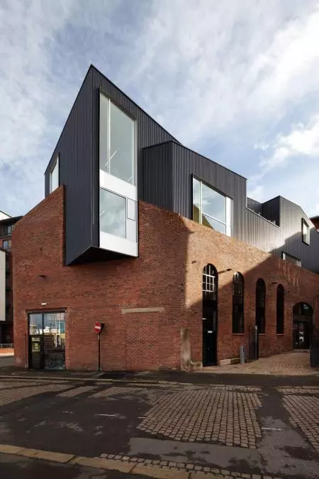 From architects Project Orange comes this fascinating extension on top of an old Victorian industrial brick building. The new black roof literally cuts through the original shell with the parasite completely overwhelming its host