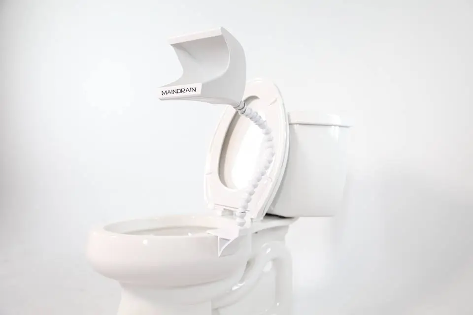 It consists of a urine-receiving head designed to reduce splashing, an articulated hose, and a clip where the liquid comes out, that hooks over the edge of the toilet bowl