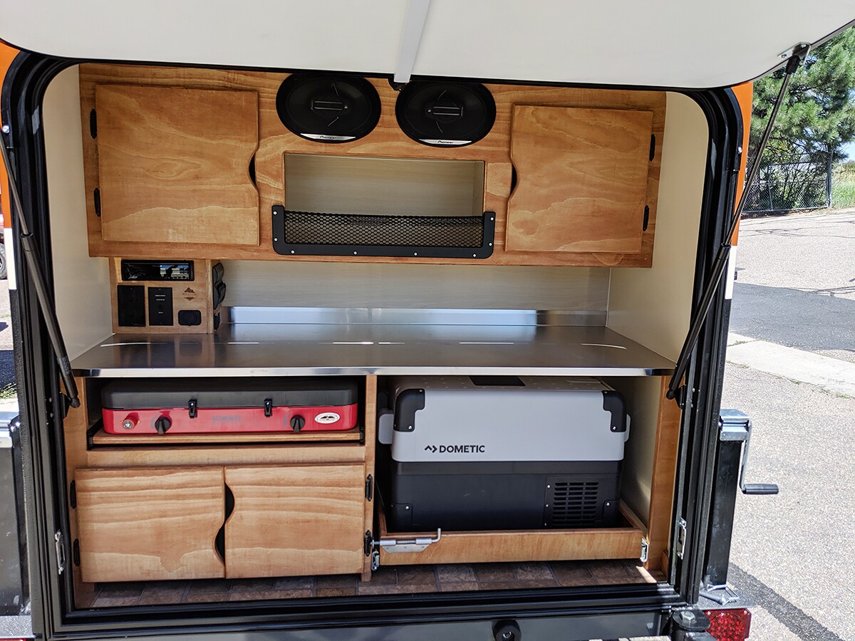 No plumbing here, but the galley comes standard with a stainless counter, audio system and Camp Chef stove; fridge is available optionally