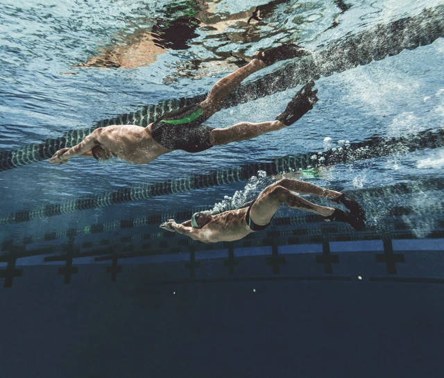 According to Speedo, this design creates more surface area for the water to pass over (as opposed to a straight edge), thus allowing the swimmer to go faster by pushing more water with every kick