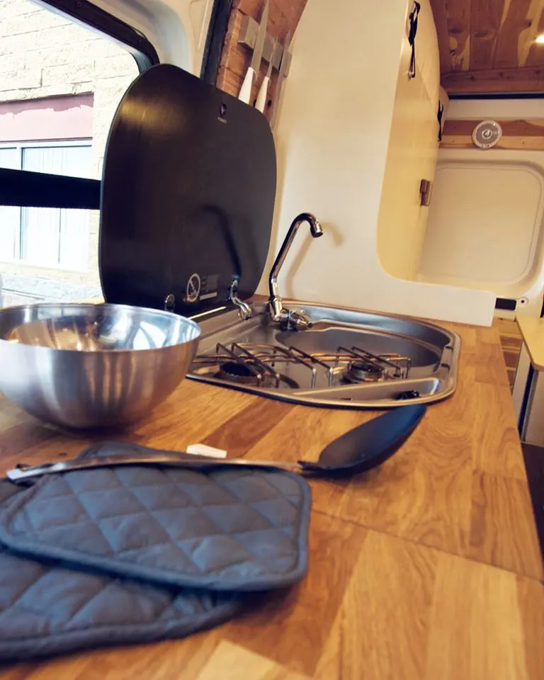 The kitchen includes a butcher block worktop and sink/dual-burner unit