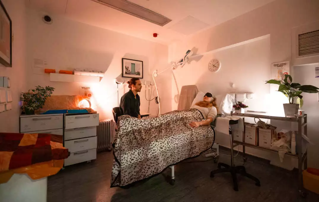 Lead researcher Christopher Timmermann overseeing a healthy volunteer in the treatment room where they are administered DMT and changes to brain activity observed