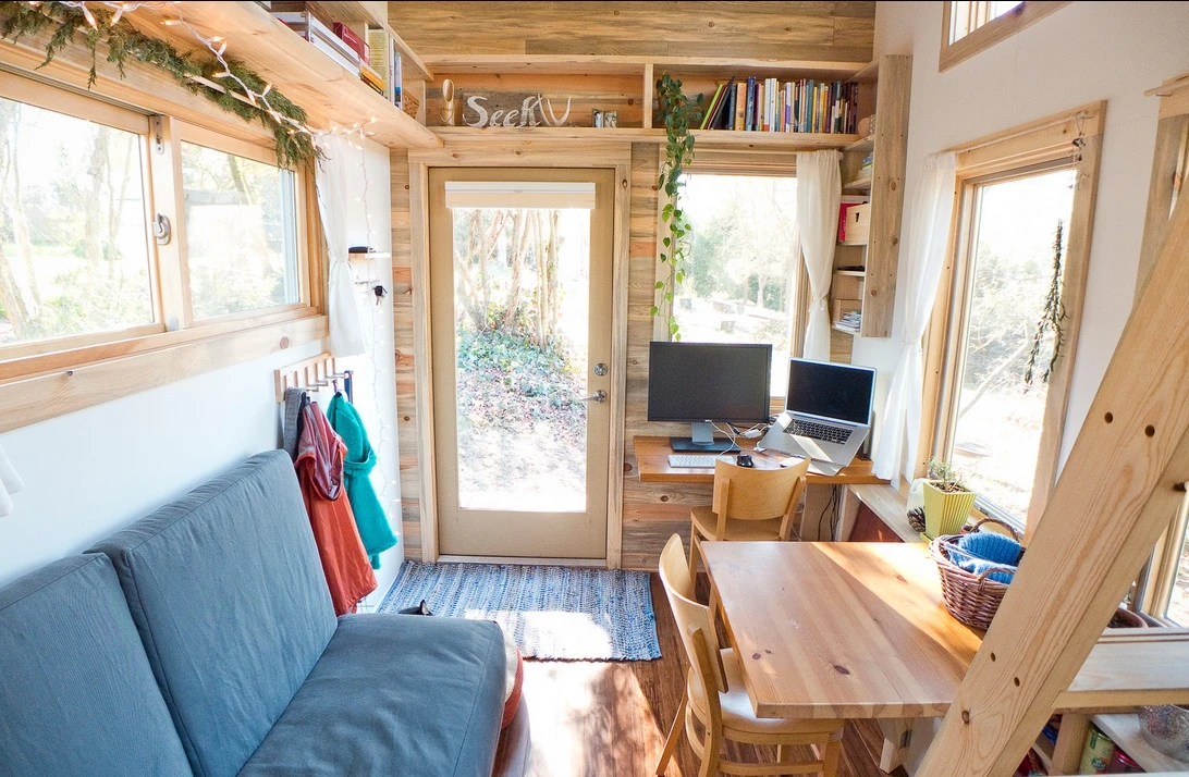 The interior of the micro home consists of a main living area with high ceilings, elevated loft bedroom, mini kitchen and bathroom