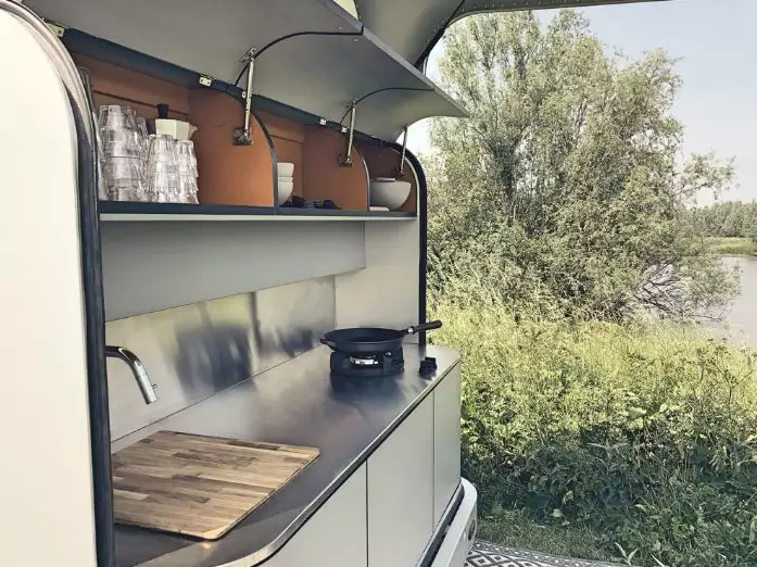 Lume's flagship "No. 1" model includes a tailgate kitchen with floating burners and a wood cutting board/sink cover