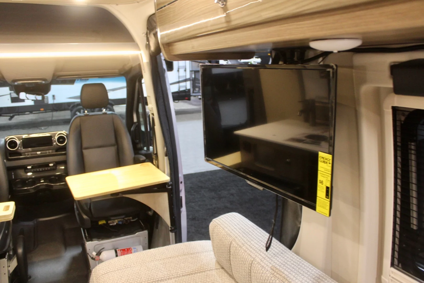 Both floor plans include a 24-in TV mounted on the passenger side of the bed/lounge area