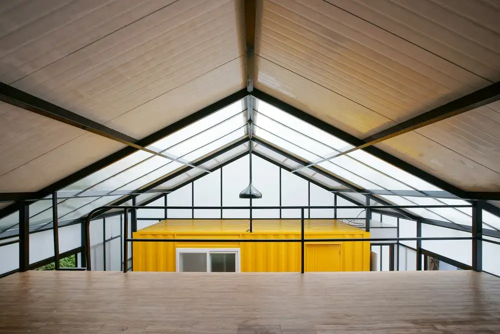 The budget-friendly Low Cost House in South Korea features three shipping containers placed within a surrounding structure in order to provide a safe and attractive home for a family of seven