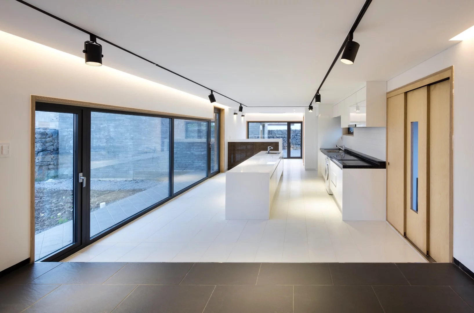 The three vacation homes are integrated into one low-lying concrete building that sports volcanic rock walls and a clean minimalist interior