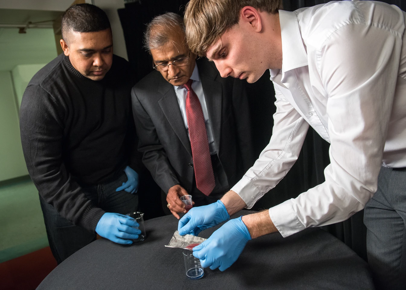 Bharat Bhushan (center), research assistant Dave Maharaj (left) and postdoctoral researcher Philip Brown (right) test the mesh (Photo: Jo McCulty/The Ohio State University)