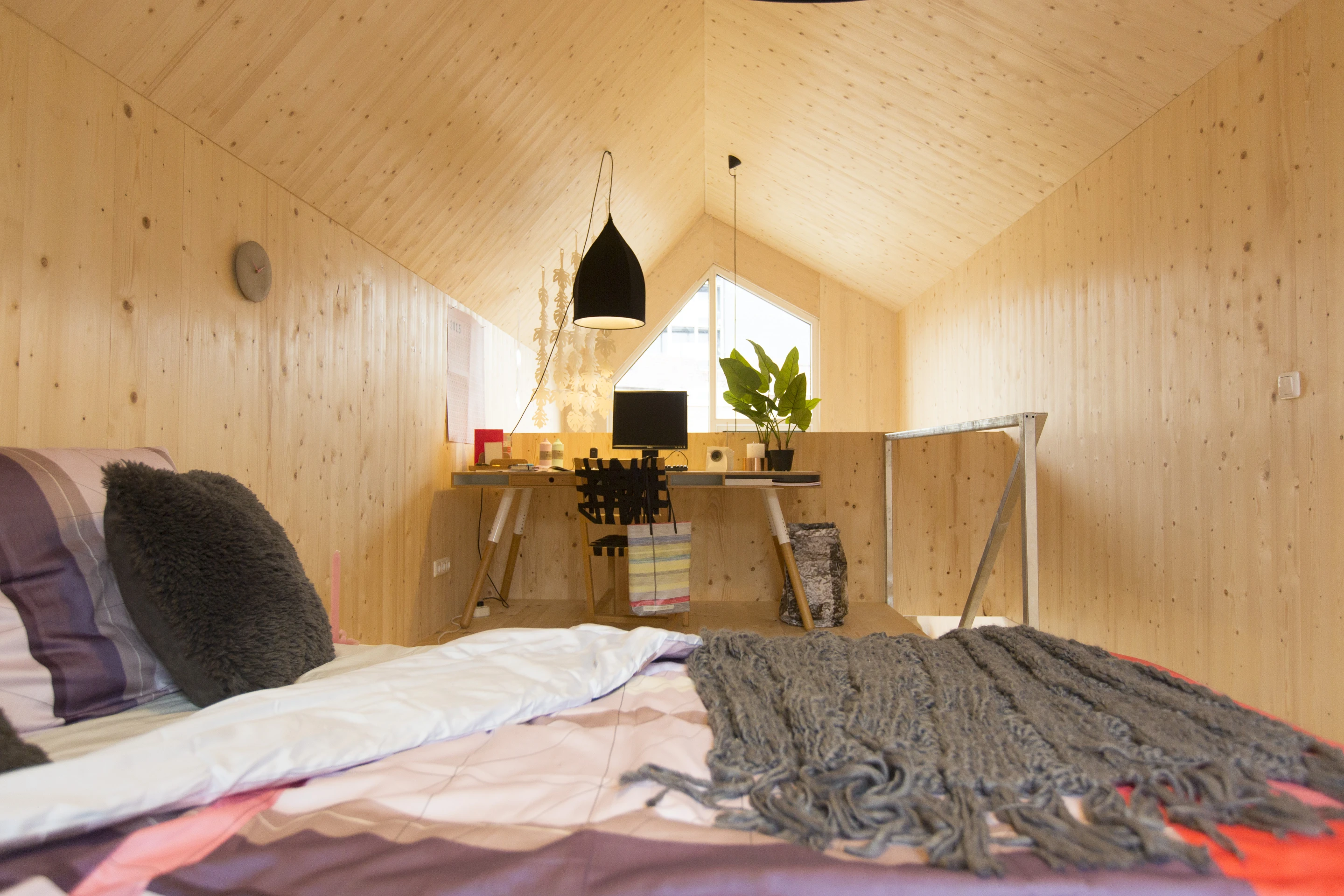 A bedroom and small desk area is located in the mezzanine upstairs