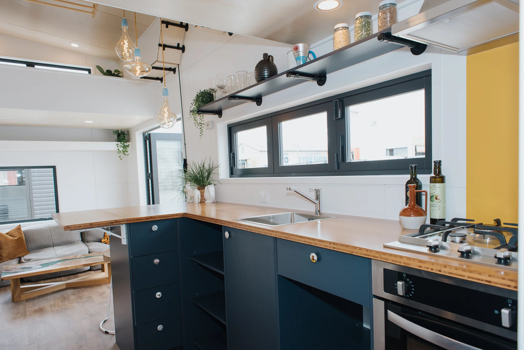 Cyril the Tiny House's kitchen includes a small stainless steel sink and quite a lot of storage space for a compact tiny house