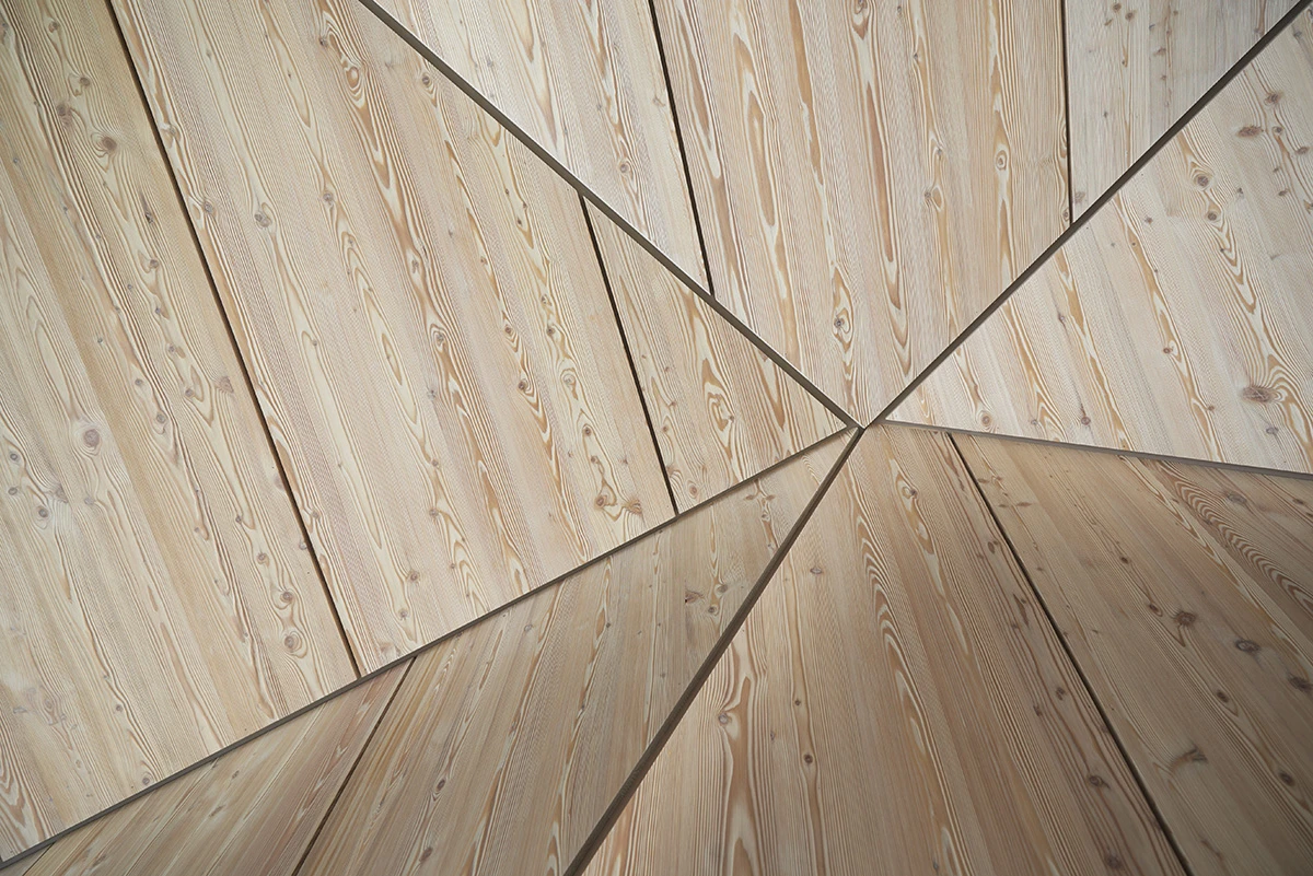 Filled with angular and geometric shapes, the walls and ceilings are clad with wooden panels