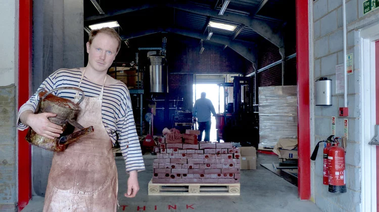 Alex Chinneck posing with wax bricks (Photo: Tommophoto)