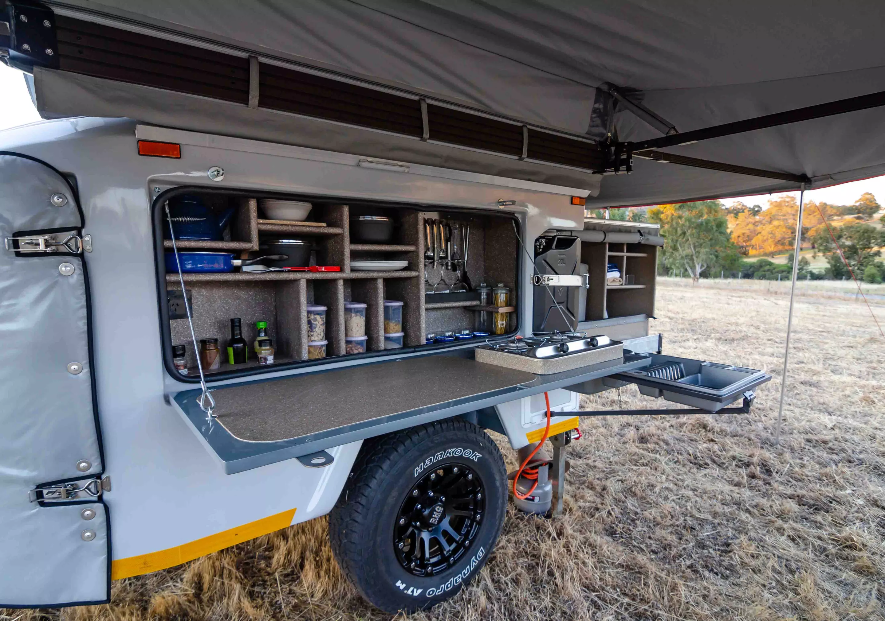 The large side hatch includes a dual-burner stove on the inside of the door and a neatly organized pantry