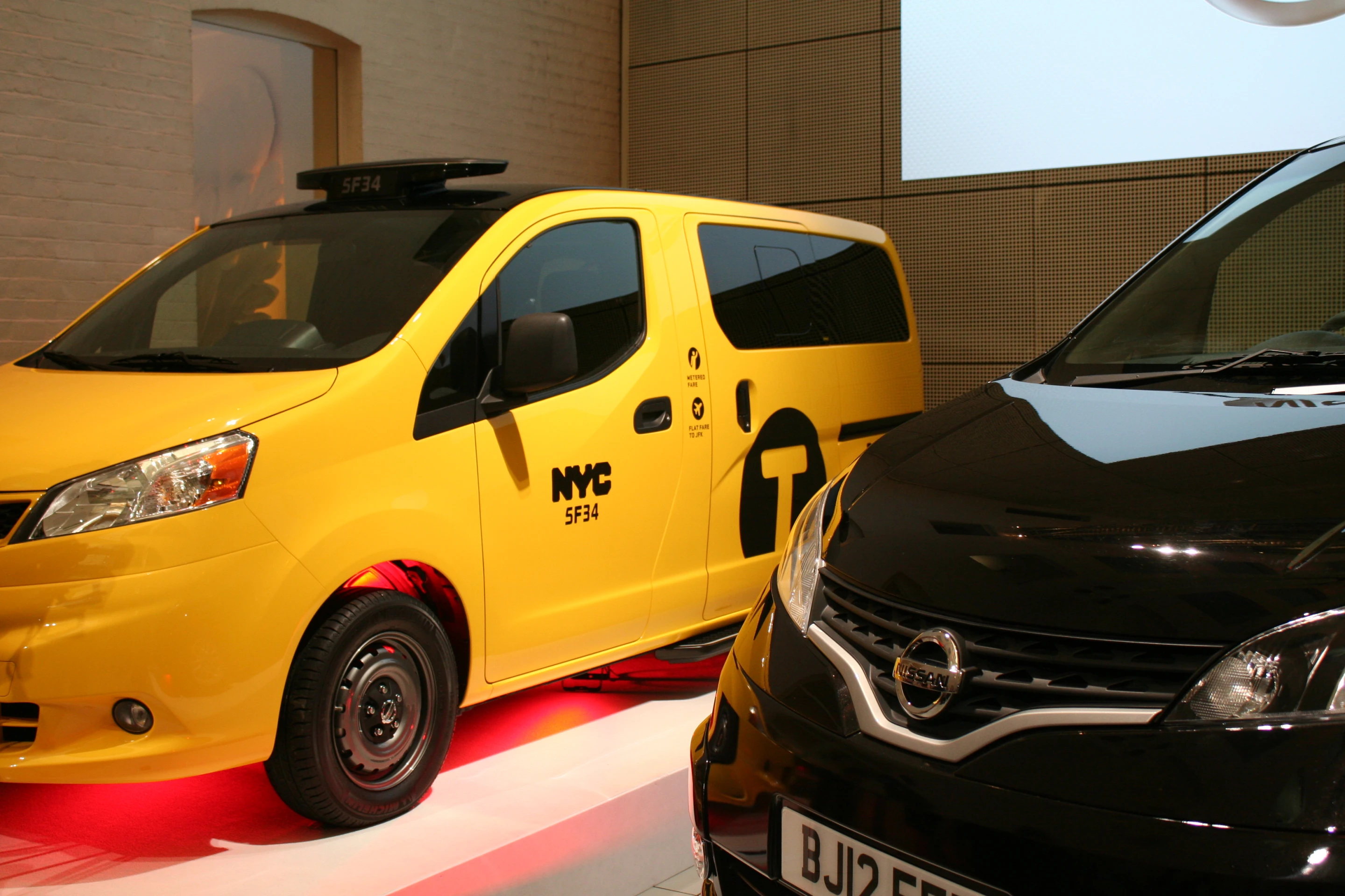 The London model of the NV200 on display next to the New York version (Photo: Gizmag)