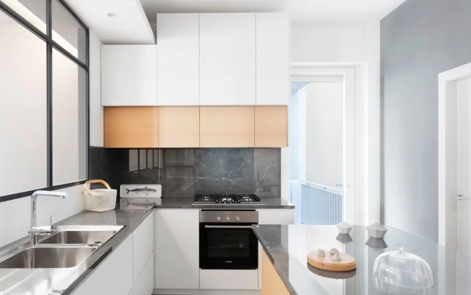 The kitchen is complete with beautiful granite benchtops and ample built-in storage cupboards that take advantage of the home's tall ceilings