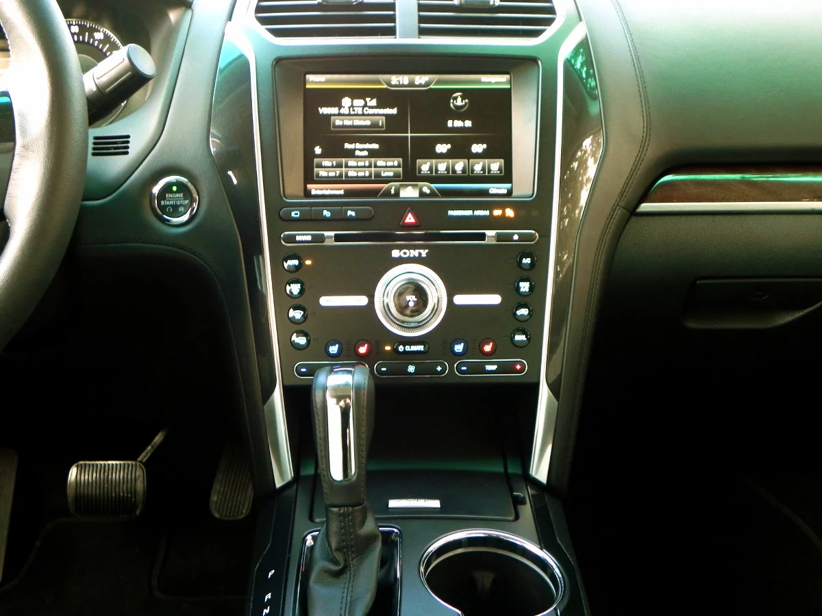 The self-parking activation button is located below the infotainment in the center of three buttons, marked by a P with a steering wheel next to it