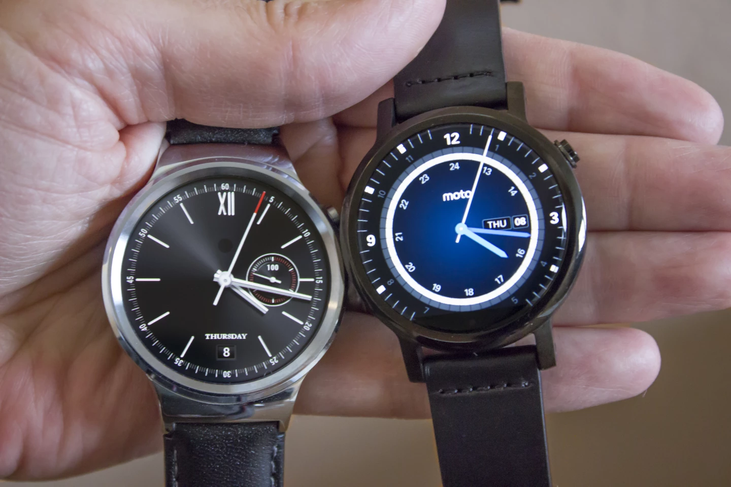 Huawei Watch and 42 mm Moto 360 in hand
