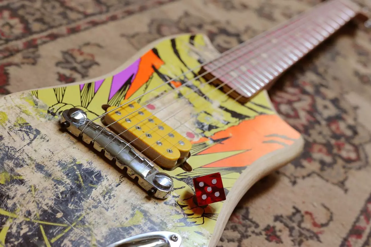 The yellow open coil humbucking pickups complement the skateboard's original design perfectly, and what about that volume knob?