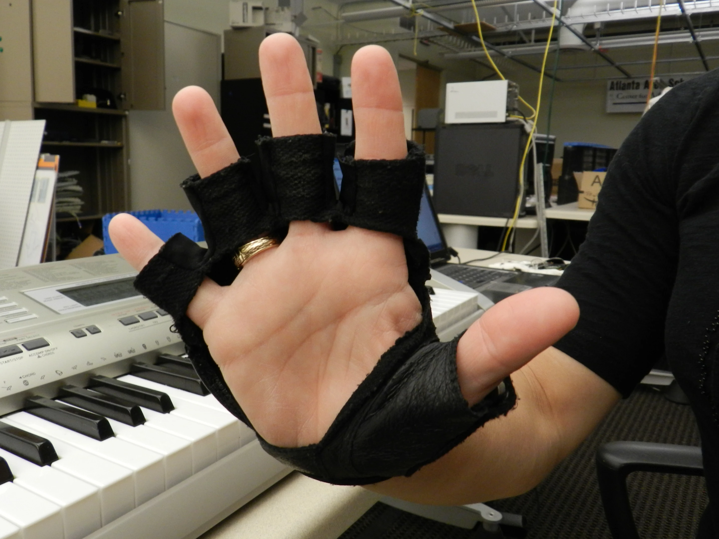 The MMT glove vibrates to indicate which finger to tap the piano keyboard with