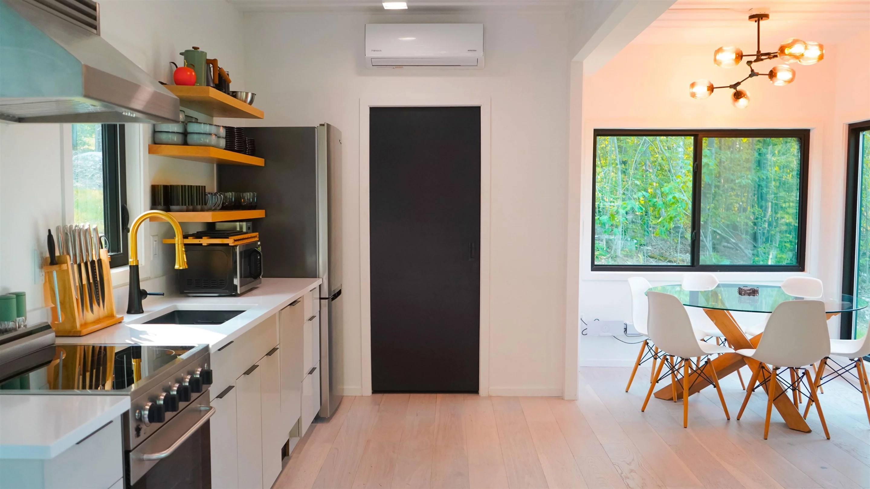 The Vermont Villa's kitchen includes an oven and cooktop, a full-size fridge/freezer, a sink, microwave, and a dining table for four