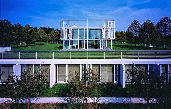 Front view of Taghkanic House, showing the glass windows and doors of several of the bedrooms and the glass pavilion rising above (Photo: T. Phifer and Partners)