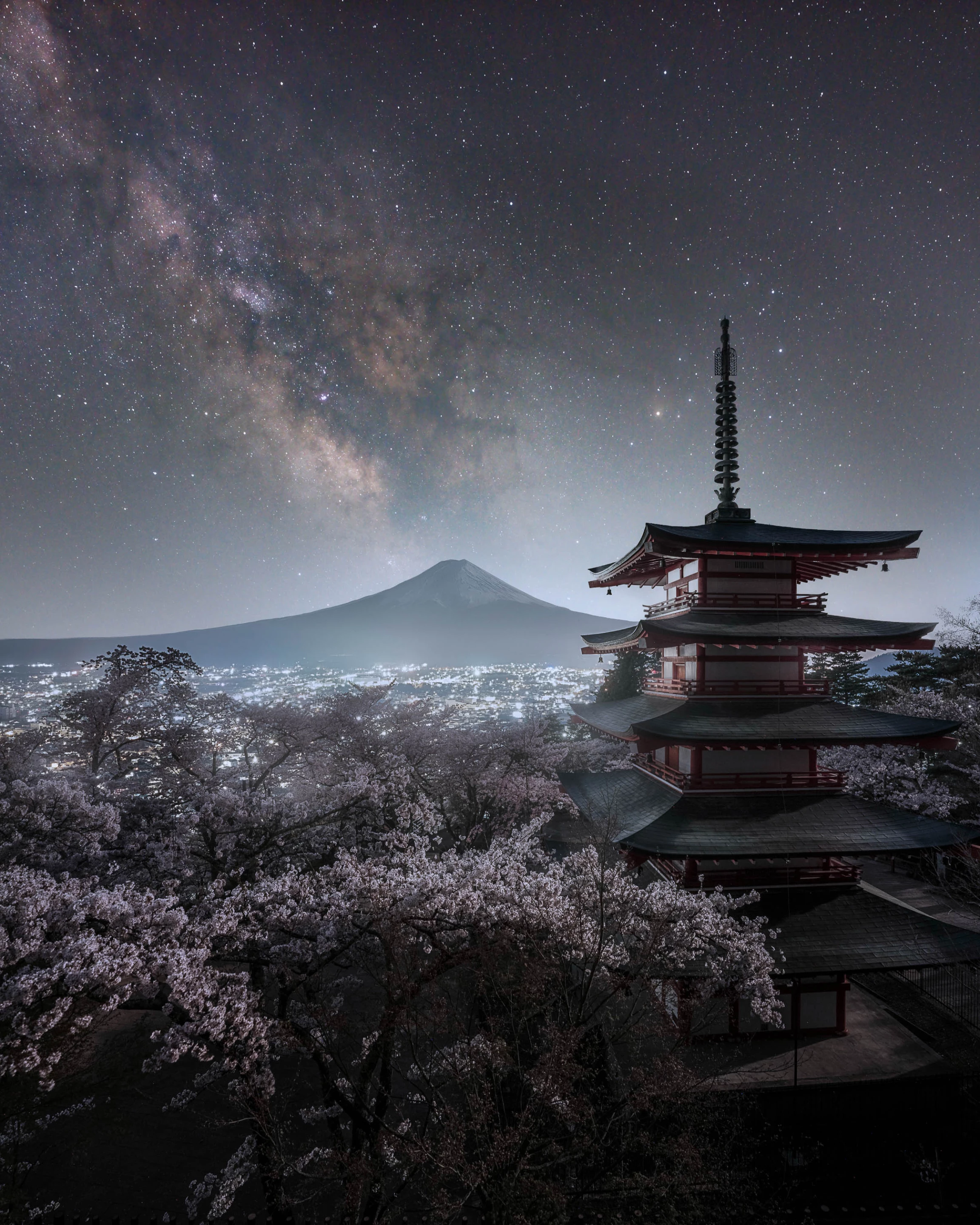 The Scenery I Wanted to See by Mitsuhiro Okabe, shot in Yamagashi Prefecture, Japan. The Milky Way hovers over Mount Fuji, a temple and the cherry blossoms in full bloom