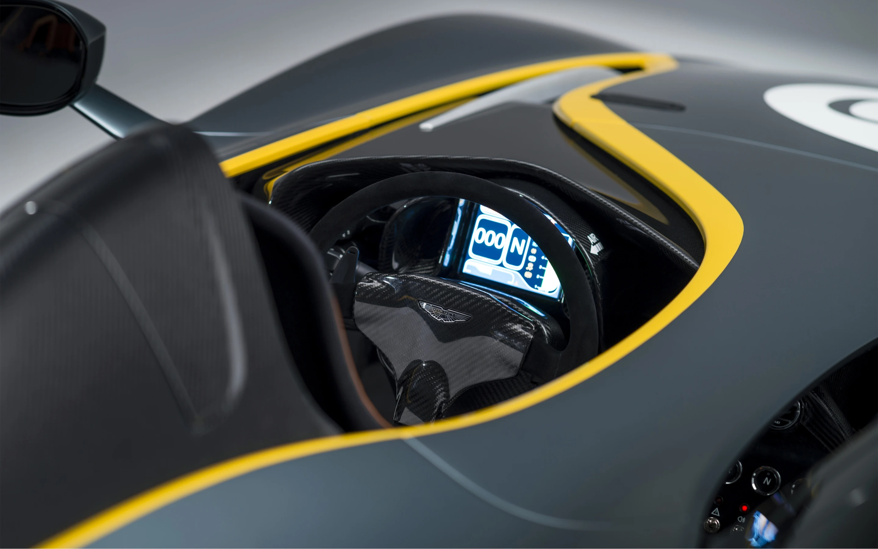 Cozy minimalist driver area is segregated from the passenger by a splitting body feature that flows from tip to tail