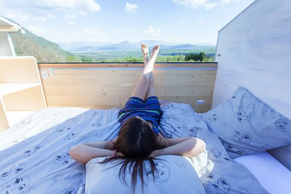 La Tête dans les étoiles' loft bedroom is a typical tiny house style but with one exception: the roof slides open