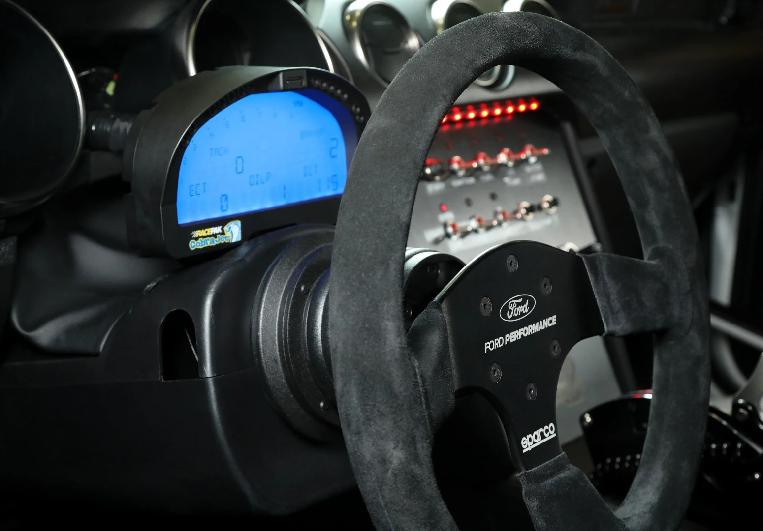 Race-ready accouterments are seen inside the Cobra Jet, including FIA and NHRA approved safety equipment