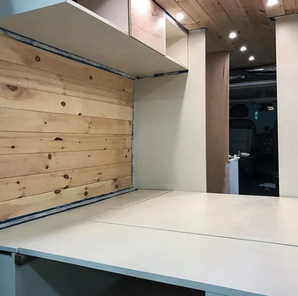 The Murphy bed platform appears to rest on the passenger-side bench and a support along the base of the driver-side bench