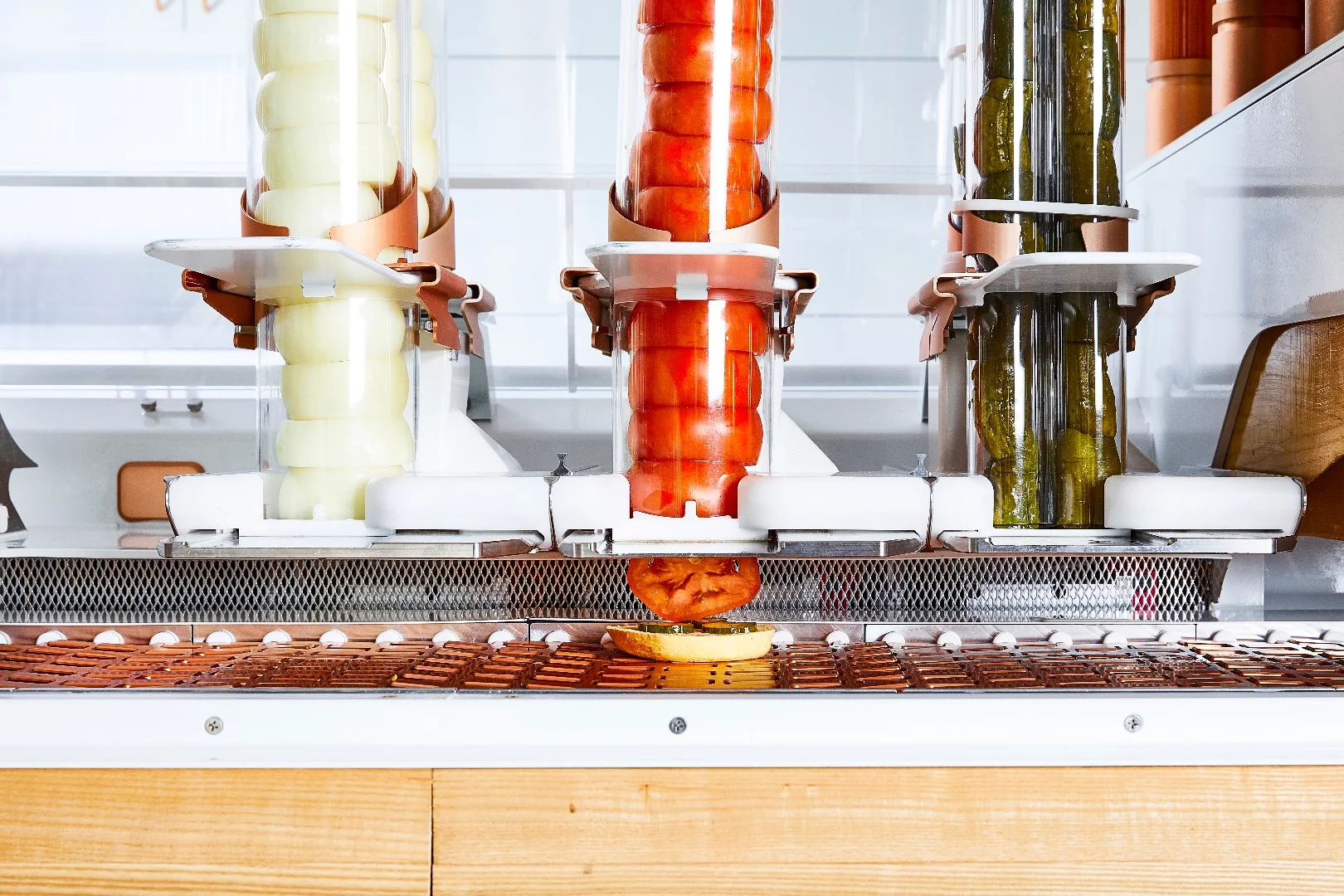 Toppings such as onions, tomatoes and pickles go into the Creator robot whole, and are then sliced to order