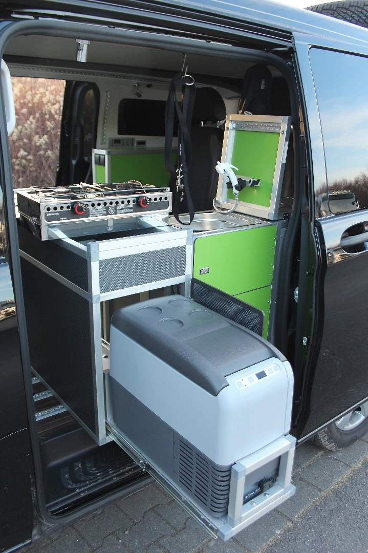 The Dogscamper's indoor/outdoor kitchen includes a removable camping stove and slide-out refrigerator