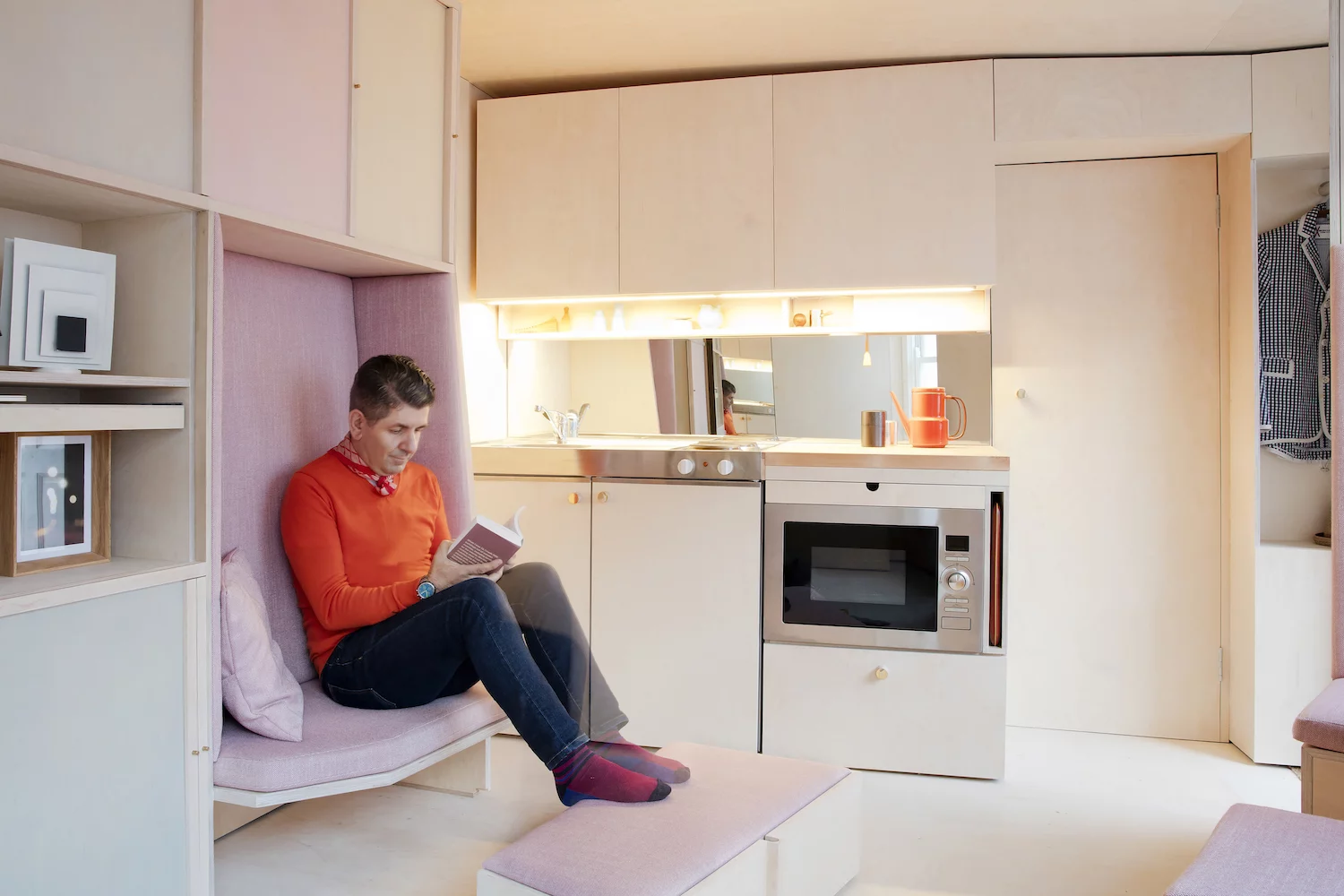 The 13 sq Metre House's small seating area being used gives a sense of scale