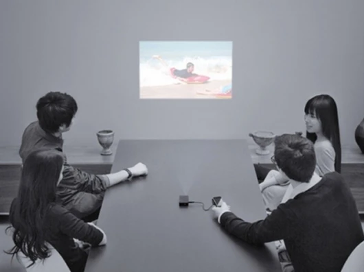 Work colleagues feigning interest in the boss' holiday movies