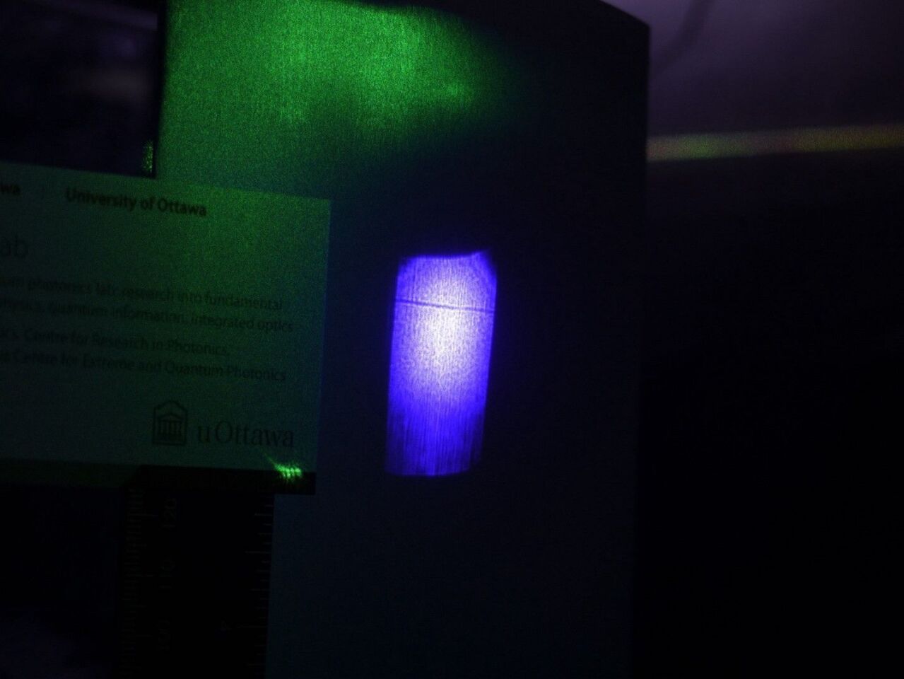 The shadow of a laser beam can be seen as the small dark line across the blue light