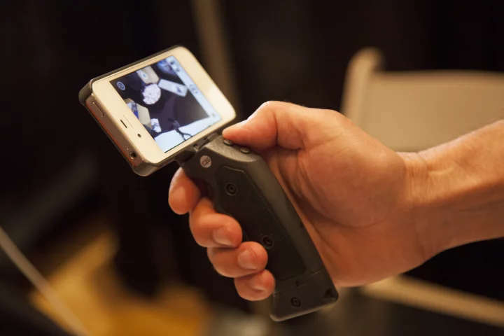 The Grip & Shoot system attaches an ergonomic pistol grip to an iPhone and connects via Bluetooth, providing greater control when taking photos and shooting video