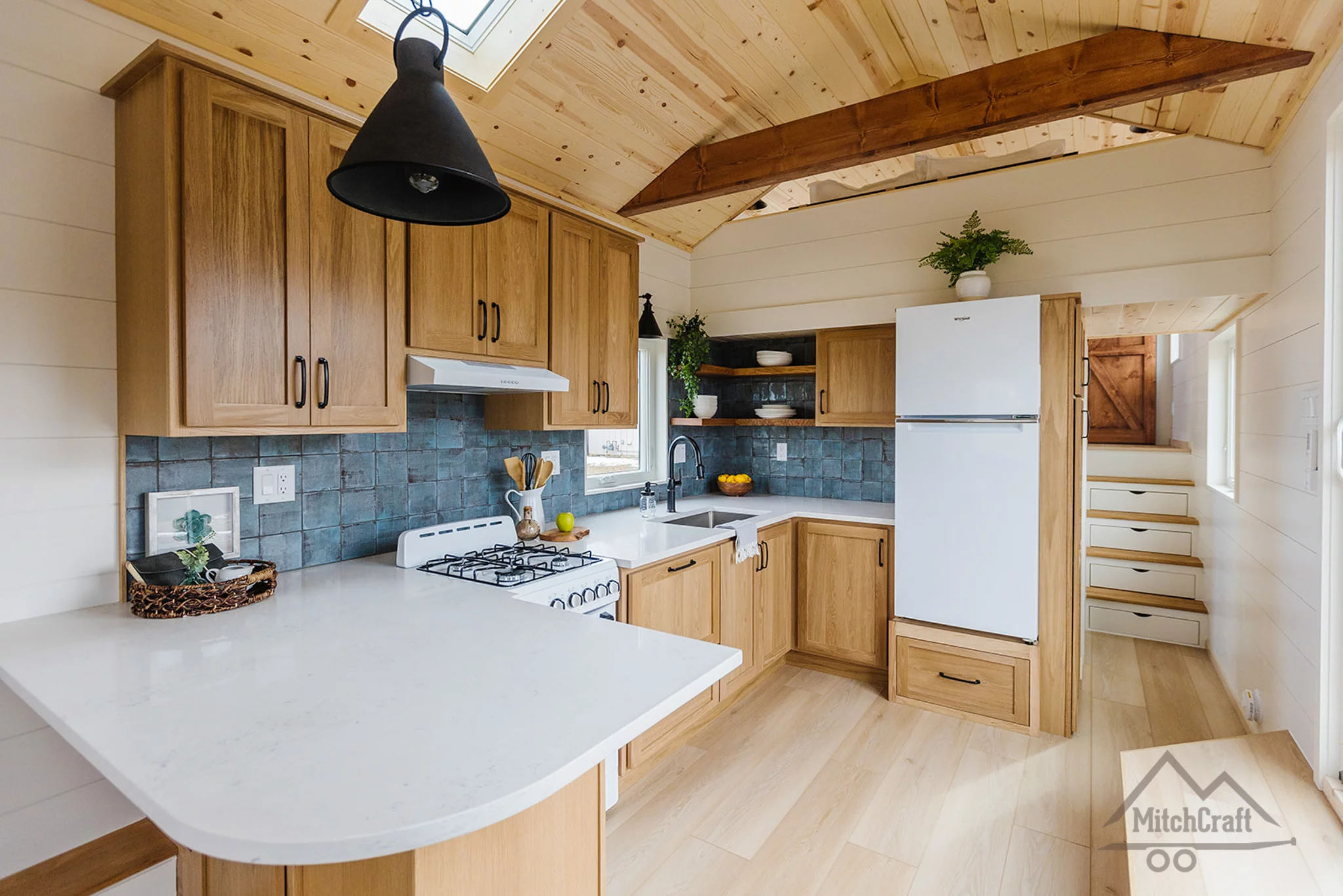 The kitchen in the CC 31' x 10' includes a fridge/freezer plus an oven with a propane-powered four-burner stove