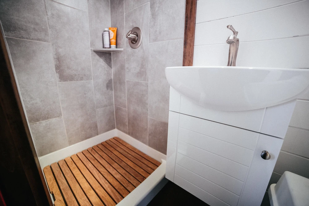The bathroom features shower, sink, and composting toilet