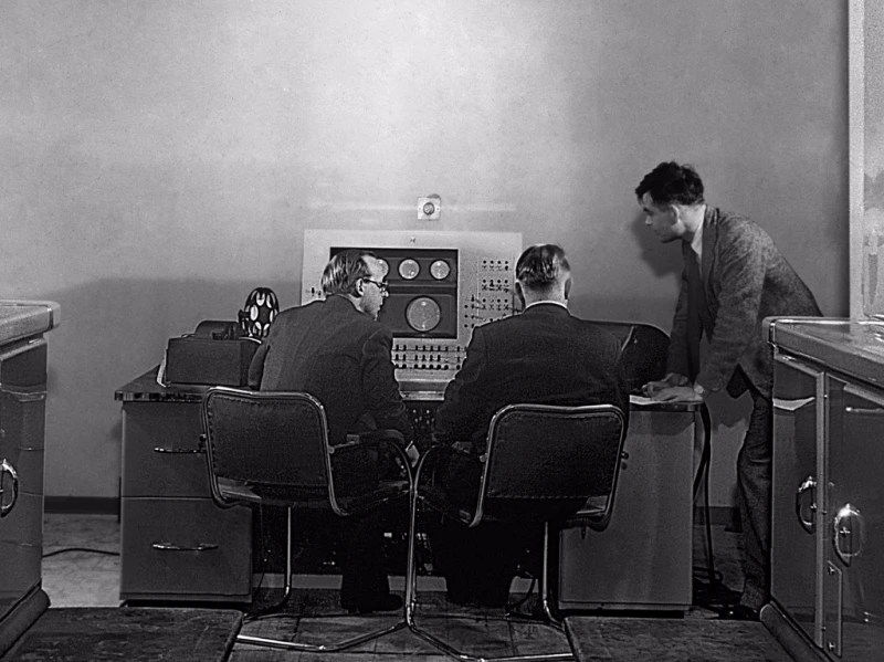 Turing (right) at the console of the Ferranti Mark I