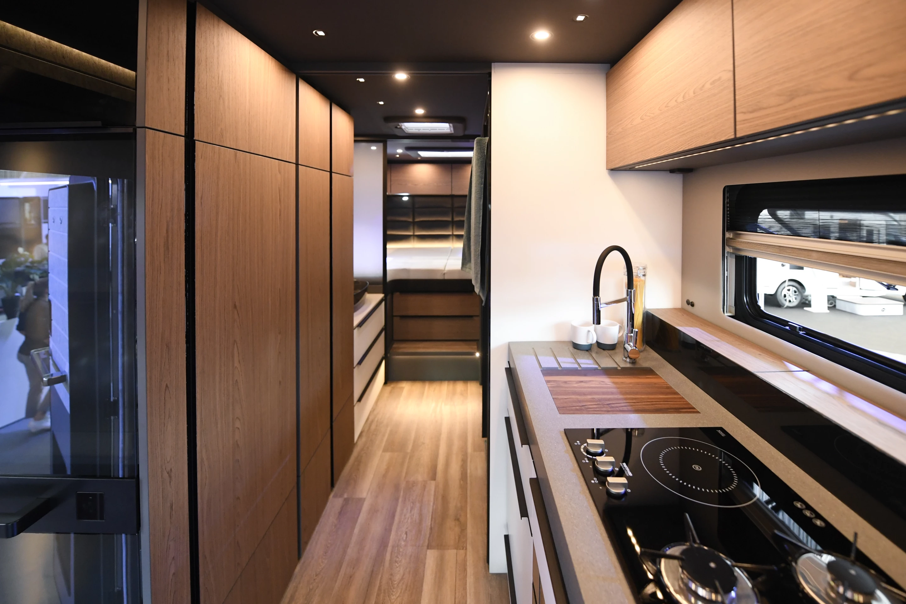 The versatile kitchen design includes and electric-retractable hood and a hybrid cooktop