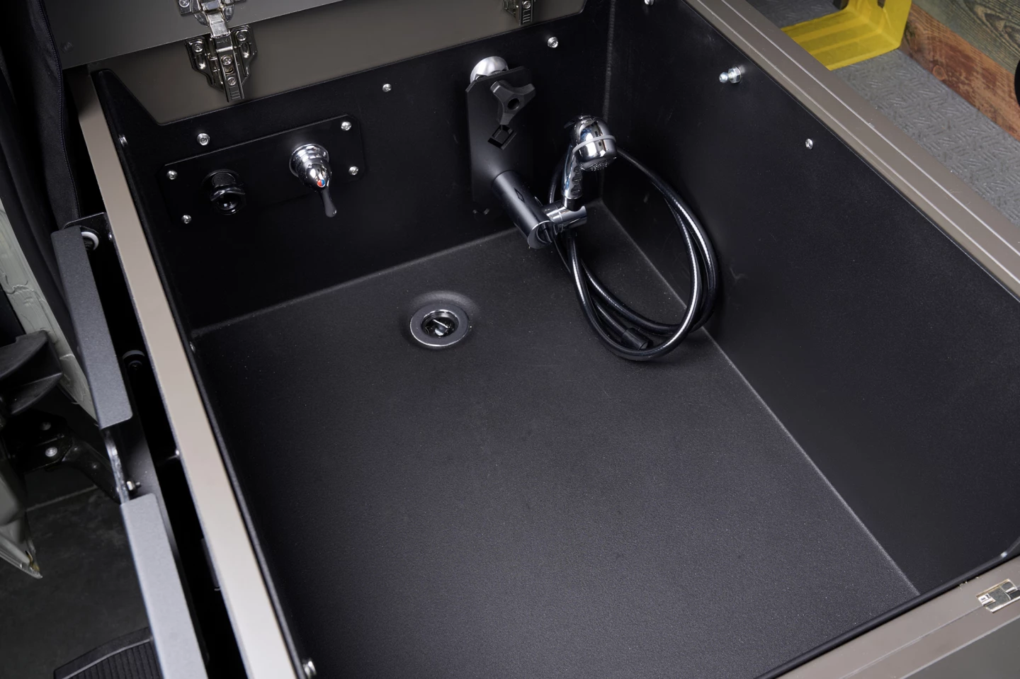 The passenger side bench is also the collapsible shower and can hold a portable toilet
