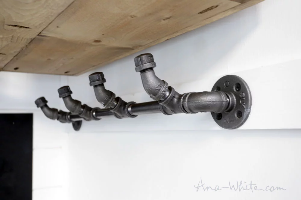 This Open Concept Rustic Modern Tiny House's clothes hangar is made from piping