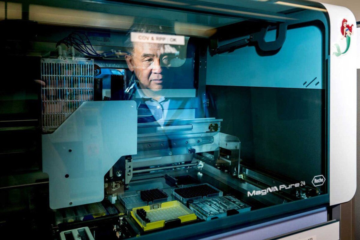 UCSF microbiologist Charles Chiu watches as a robot extracts DNA from a sample