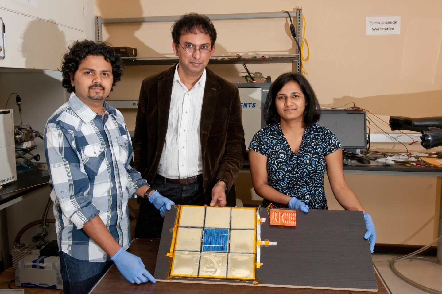 Rice University graduate student Charudatta Galande, Professor Pulickel Ajayan and graduate student Neelam Singh show off the first test device for their paintable batteries (Photo: Jeff Fitlow/Rice University)
