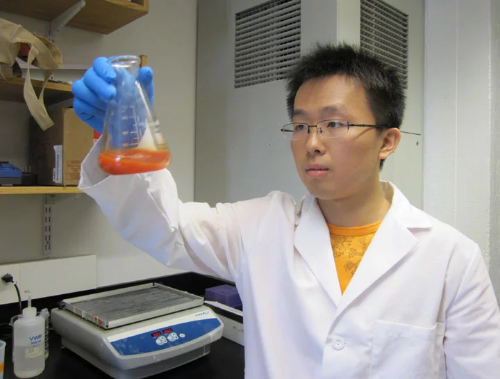 Brown University's Qi Wang swirls a solution of selenium nanoparticles
