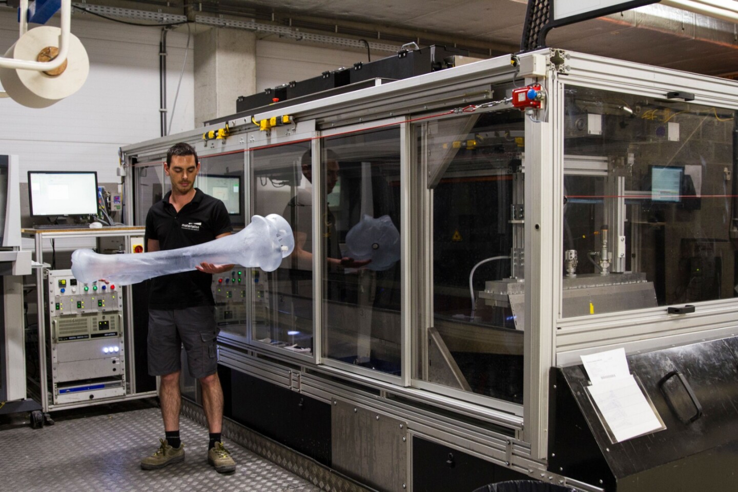 One of the 3D-printed mammoth bones, alongside one of the Mammoth Stereolithography large-format printers