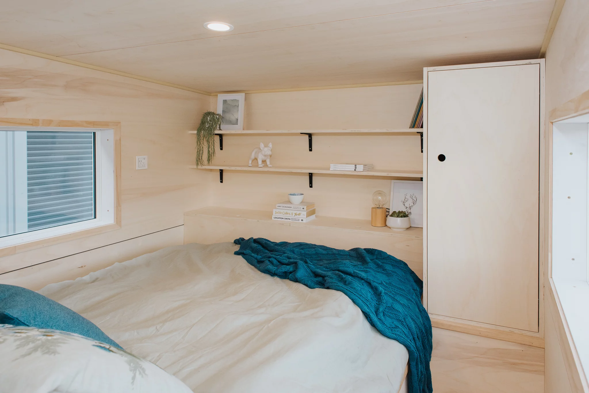 The Total Grace's bedroom includes a double bed and some shelving and a wardrobe