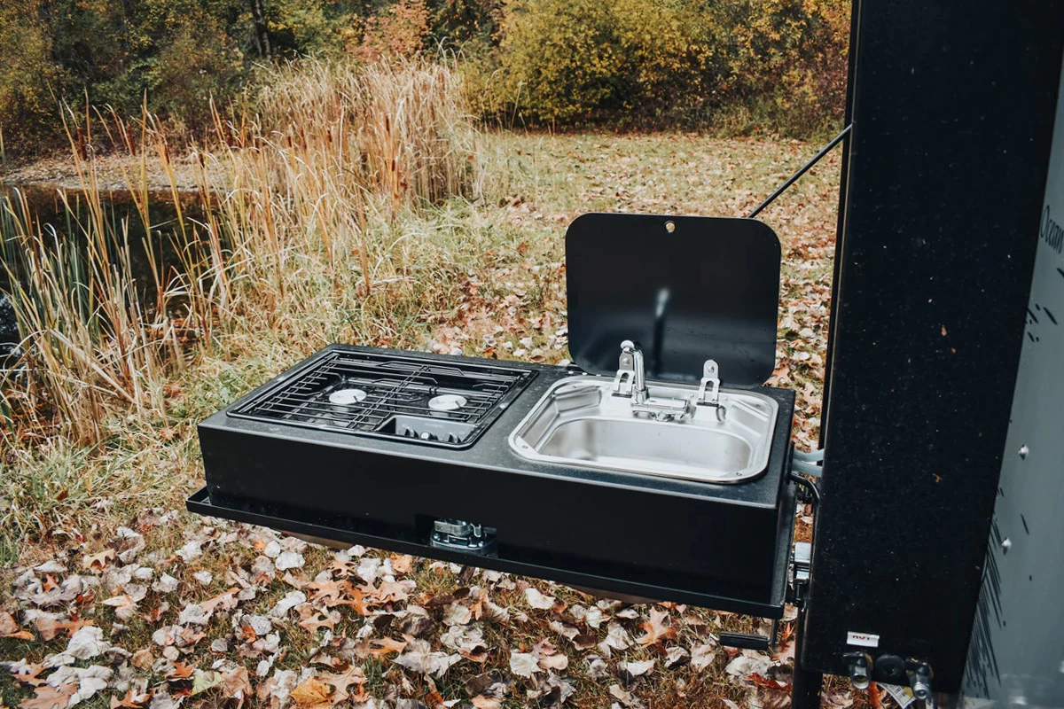 The aluminum galley kitchen includes a slide-out prep counter, and neatly folds out of sight when not in use