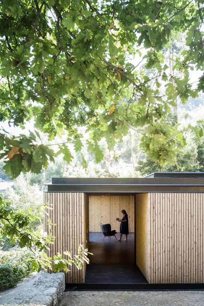 Pavilion House is a timber-clad home built above a pre-existing wine cellar, located amid a stunning vineyard in Guimarães, Portugal
